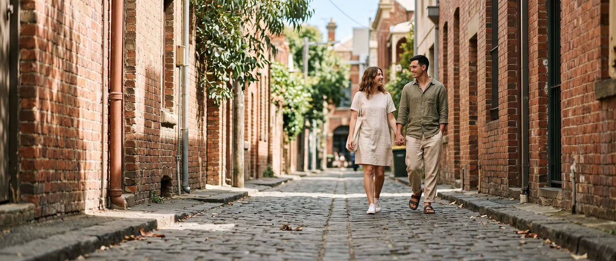 Woman and man walking hand in hand along a sunny Melbourne laneway